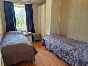 1 dormitorio con 2 camas y ventana en Otnes Fjordside en Aurland