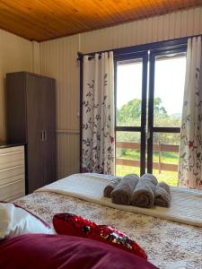 a bedroom with a bed and a window with towels at Mountain House in Bom Jardim da Serra
