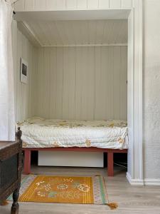 een slaapkamer met een bed in een kamer met een tapijt bij Idyllic small farm appartment in Tønsberg