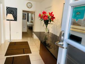 a hallway with a vase of red flowers on a counter at Ferndale Mews in Bristol
