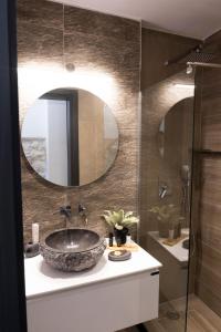 a bathroom with a sink and a mirror at VENUS LUXURY APARTMENT in Ermoupoli