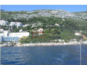 una casa en la cima de una colina junto al agua en Apartment Helena, en Dubrovnik
