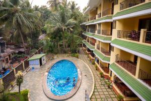 an overhead view of a swimming pool in front of a building at Ronne's ZED Penthouse and apartment in Arpora