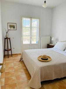 a bedroom with a bed with a hat on it at Vintage lover's getaway in Andiparos