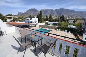 a patio with a table and chairs on a roof at NORMA'S VILLAGE in Kalymnos