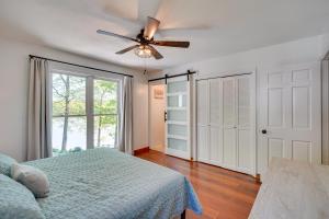 a bedroom with a bed and a ceiling fan at Lakefront Vacation Rental with Views and Hot Tub! in Bracey
