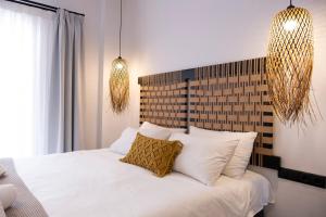 a bedroom with a bed with white sheets and pillows at VENUS LUXURY APARTMENT in Ermoupoli