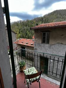 einen Balkon mit einem Stuhl und Blick auf ein Gebäude in der Unterkunft Casa Piglione in Pian dʼOrsina