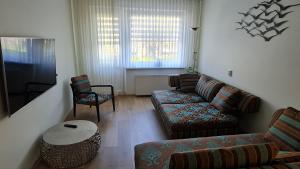 - un salon avec un canapé et une table dans l'établissement Jaukūs namai-Home Sweet Home, à Klaipėda