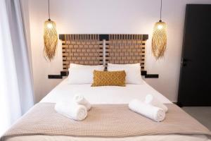 a bedroom with a large white bed with two towels at VENUS LUXURY APARTMENT in Ermoupoli