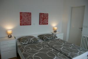 a bedroom with a bed with two pictures on the wall at Apartment Majatalo in Zagreb