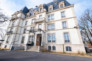 un grande edificio bianco con tetto blu di L'appartement du château a Morvillars