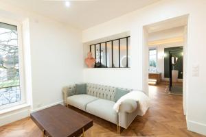 uma sala de estar com um sofá e uma mesa em L'appartement du château em Morvillars