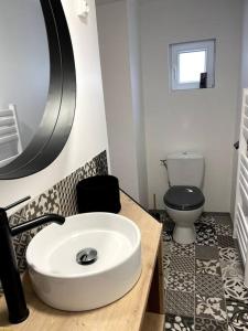 een badkamer met een witte wastafel en een toilet bij Bel appartement sur cour plein centre ville et parking in Moulins
