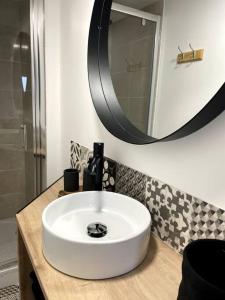 a bathroom with a white sink and a mirror at Bel appartement sur cour plein centre ville et parking in Moulins