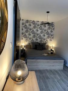 a bedroom with a bed and a table with a lamp at Bel appartement sur cour plein centre ville et parking in Moulins