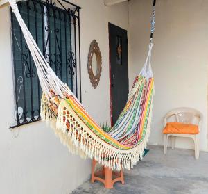 a hammock hanging on a wall in front of a door at Tocumen Sweet Home in Cabuya