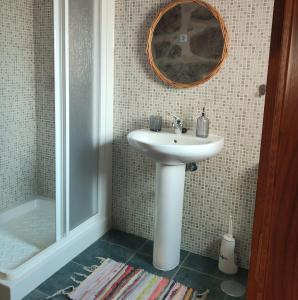 a bathroom with a white sink and a mirror at Casa Ribadil in Crecíente