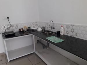 a kitchen with a sink and a counter top at MUNNAR FALCUNS in Anachal