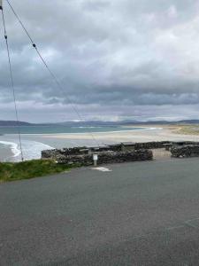 a road with a view of a beach and the ocean at Paddys in Glenties