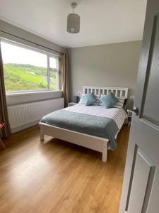 a bedroom with a bed and a large window at Paddys in Glenties