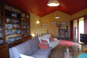 a living room with a white couch and a tv at Cardenha do Douro in Mesão Frio