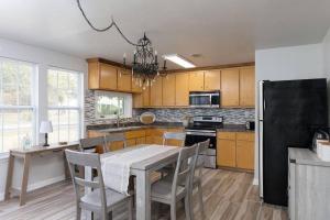 a kitchen with a table and a black refrigerator at Trout Bayou 2BR/2BT Canal in Milton