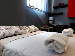 een slaapkamer met een bed met een witte handdoek erop bij Grape's Home in Canelli