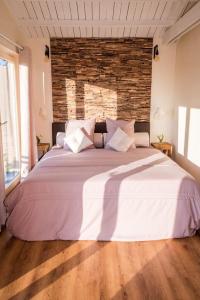 Cama blanca grande en habitación con pared de ladrillo en La vie en rose - A chalet in the nature with fenced garden, en Torhout