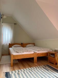 1 dormitorio con 2 camas individuales en un ático en Hegyi Füge Vendégház, en Csopak