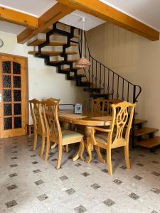 uma sala de jantar com uma mesa e cadeiras e uma escadaria em Hegyi Füge Vendégház em Csopak