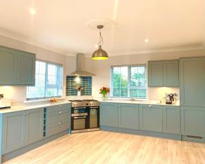una grande cucina con armadi blu e pavimenti in legno di The Lake House Dungloe a Dungloe