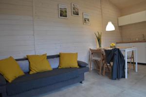 a blue couch with yellow pillows next to a table at Folwarczna 6 in Zwierzyniec