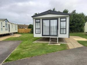a tiny house with a ladder in a yard at Withernsea luxury caravan hire in Waxholme