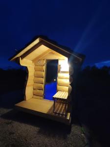 una piccola casa fuori casa con una panchina in camera di notte di Domki letniskowe a Jedlinsk