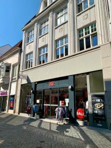 un magasin devant un bâtiment dans une rue de la ville dans l'établissement TOP-Zentrum Fußgängerzone, 81 qm, Küche, Parkplatz, à Oldenbourg