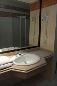 La salle de bains est pourvue d'un lavabo avec miroir et d'un téléphone. dans l'établissement Delta best, à Charm el-Cheikh