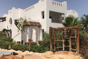 une maison blanche avec une porte en face dans l'établissement Delta best, à Charm el-Cheikh