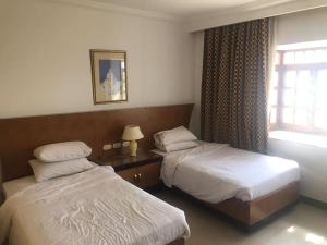 Cette chambre comprend 2 lits et une fenêtre. dans l'établissement Delta best, à Charm el-Cheikh