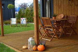 兹维日涅茨Folwarczna 6的木制甲板配有桌椅和南瓜