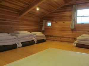 Habitación con 2 camas en una cabaña de madera en Villa Orange Cabin en Fujikawaguchiko