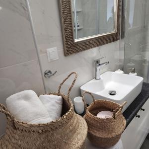 a bathroom with two baskets and a sink at Karystos sea side apartment in Karistos +24 photos