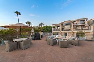 une terrasse avec des canapés, un parasol et une table dans l'établissement Villa Calypso, à Laguna Beach