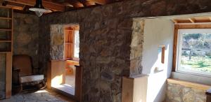 Habitación con pared de piedra y ventana. en Olympos stone villa 2, en Kumluca