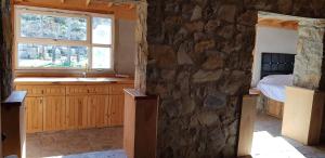 - une chambre dotée d'un mur en pierre avec un lit et un lavabo dans l'établissement Olympos stone villa 2, à Kumluca