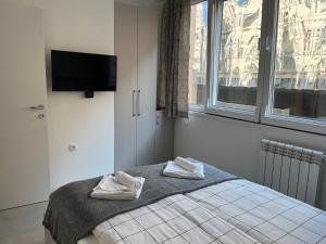 een slaapkamer met een bed met twee handdoeken erop bij Sveti Stefan in Belgrado