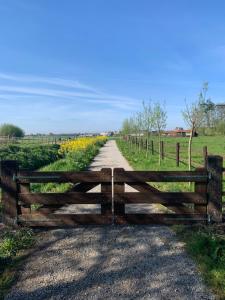 una valla de madera al lado de un camino de tierra en Fields 1216 en Zwaanshoek