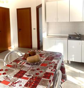 une cuisine avec une table et un chiffon de table. dans l'établissement "La Casa di FRILA" Bilocali a Borgo Celano, à San Giovanni Rotondo