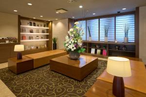 a living room with a couch and a table with flowers at Hotel Resol Machida in Machida