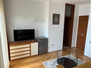 a living room with a flat screen tv on a dresser at Old Town Heritage by Mrav in Sukošan